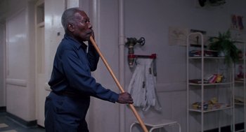 Movie still from “Awakenings” (1990), directed by Penny Marshall – An older man holding a wooden stick in a room; Medium shot, Low angle