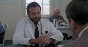 Movie still from “Awakenings” (1990), directed by Penny Marshall – A man sitting at a table in front of two other men; Close Up shot, Over the shoulder angle