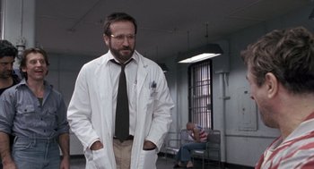 Movie still from “Awakenings” (1990), directed by Penny Marshall – A man in a white lab coat standing in a room; Medium shot, Low angle
