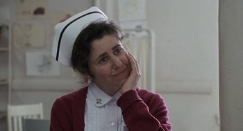 Movie still from “Awakenings” (1990), directed by Penny Marshall – A woman wearing a nurse's uniform and a hat; Close Up shot, Over the shoulder angle