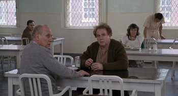 Movie still from “Awakenings” (1990), directed by Penny Marshall – Two men and a woman sitting at a dining table; Medium shot, Over the shoulder angle