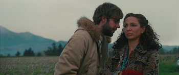 Movie still from “Away We Go” (2009), directed by Sam Mendes – A man and a woman standing next to each other in a field; Medium shot, Low angle