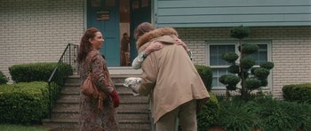 Movie still from “Away We Go” (2009), directed by Sam Mendes – A man is hugging a woman outside of a house; Wide shot, Over the shoulder angle