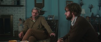 Movie still from “Away We Go” (2009), directed by Sam Mendes – A man sitting next to another man in a room; Medium shot, Over the shoulder angle