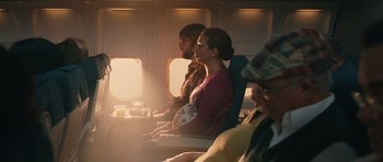 Movie still from “Away We Go” (2009), directed by Sam Mendes – A group of people sitting on a plane looking out the window; Wide shot, Over the shoulder angle