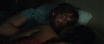 Movie still from “Away We Go” (2009), directed by Sam Mendes – A man with a beard is laying in a bed; Close Up shot, Over the shoulder angle