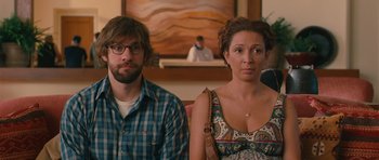 Movie still from “Away We Go” (2009), directed by Sam Mendes – A man and a woman sitting next to each other in a room; Medium shot, Over the shoulder angle