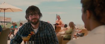 Movie still from “Away We Go” (2009), directed by Sam Mendes – A man sitting in front of a group of people; Medium shot, Over the shoulder angle