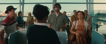 Movie still from “Away We Go” (2009), directed by Sam Mendes – A man standing in front of a group of people; Medium shot, Over the shoulder angle