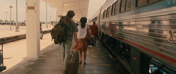 Movie still from “Away We Go” (2009), directed by Sam Mendes – A man and a woman walking down a train platform with luggage; Wide shot, Over the shoulder angle