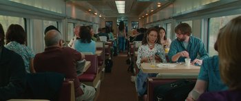 Movie still from “Away We Go” (2009), directed by Sam Mendes – People are sitting on a train eating and drinking coffee; Wide shot, High angle