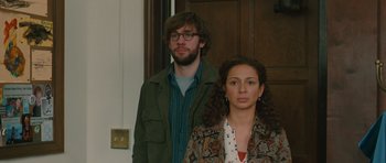 Movie still from “Away We Go” (2009), directed by Sam Mendes – A man and a woman standing next to each other in front of a door; Medium shot, Over the shoulder angle