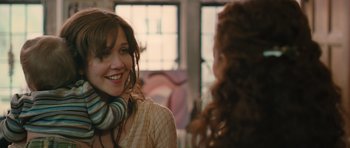 Movie still from “Away We Go” (2009), directed by Sam Mendes – A woman wearing headphones talking to another woman; Close Up shot, Over the shoulder angle