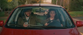 A man and a woman in a red car