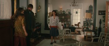 Movie still from “Away We Go” (2009), directed by Sam Mendes – A woman standing in front of a man in a living room; Wide shot, Over the shoulder angle