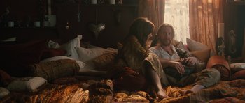Movie still from “Away We Go” (2009), directed by Sam Mendes – A man and a woman sitting on a bed in front of a window; Medium shot, High angle