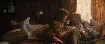 Movie still from “Away We Go” (2009), directed by Sam Mendes – A woman sitting on a bed next to a man; Medium shot, High angle