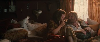 Movie still from “Away We Go” (2009), directed by Sam Mendes – A man and a woman sitting on a bed together; Medium shot, Over the shoulder angle