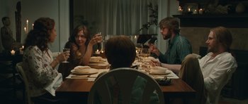 Movie still from “Away We Go” (2009), directed by Sam Mendes – A group of people sitting at a dinner table; Medium shot, Over the shoulder angle