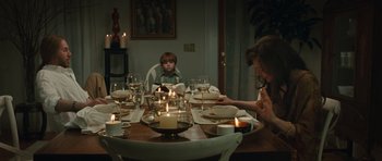 Movie still from “Away We Go” (2009), directed by Sam Mendes – A family sitting at a dinner table with candles lit; Medium shot, High angle