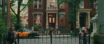 Movie still from “Away We Go” (2009), directed by Sam Mendes – A person walking on a sidewalk near a building; Extreme Wide shot, High angle