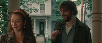 Movie still from “Away We Go” (2009), directed by Sam Mendes – A man and a woman standing in front of a house; Medium shot, Over the shoulder angle