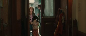 Movie still from “Away We Go” (2009), directed by Sam Mendes – A woman and a young girl standing in front of an open door; Medium shot, Over the shoulder angle