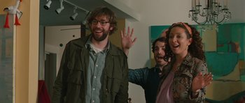 Movie still from “Away We Go” (2009), directed by Sam Mendes – A group of people that are standing in a room together; Medium shot, Over the shoulder angle