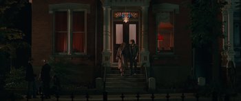 Movie still from “Away We Go” (2009), directed by Sam Mendes – Two people standing on the steps of a house; Wide shot, Low angle