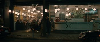 Movie still from “Away We Go” (2009), directed by Sam Mendes – Two people standing in front of a restaurant at night; Extreme Wide shot, High angle