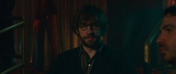 Movie still from “Away We Go” (2009), directed by Sam Mendes – A man with a beard wearing glasses and a black shirt; Close Up shot, Over the shoulder angle