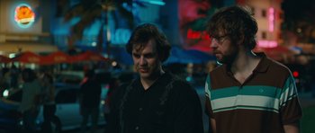 Movie still from “Away We Go” (2009), directed by Sam Mendes – Two men standing next to each other in a dark room; Medium shot, Over the shoulder angle