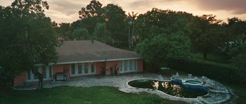 Movie still from “Away We Go” (2009), directed by Sam Mendes – A house with a pool in front of it and trees in the background; Extreme Wide shot, High angle