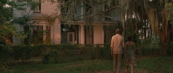 Movie still from “Away We Go” (2009), directed by Sam Mendes – A person standing in front of a house; Extreme Wide shot, Over the shoulder angle