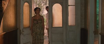 Movie still from “Away We Go” (2009), directed by Sam Mendes – A man and a woman standing in front of an open door; Wide shot, Over the shoulder angle