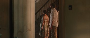 Movie still from “Away We Go” (2009), directed by Sam Mendes – A man and a woman standing in front of a staircase; Wide shot, Over the shoulder angle