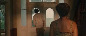 Movie still from “Away We Go” (2009), directed by Sam Mendes – A man and a woman standing in front of an open door; Medium shot, Over the shoulder angle