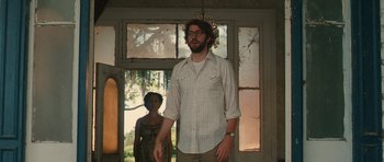 Movie still from “Away We Go” (2009), directed by Sam Mendes – A man and a woman standing next to each other in front of a window; Medium shot, Low angle
