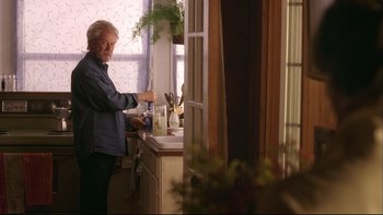 Movie still from “Away from Her” (2006), directed by Sarah Polley – An older man standing at a sink in a kitchen; Medium shot, Over the shoulder angle