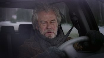Movie still from “Away from Her” (2006), directed by Sarah Polley – An older man sitting in the drivers seat of a car; Close Up shot, Low angle