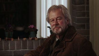 Movie still from “Away from Her” (2006), directed by Sarah Polley – An older man sitting in front of a brick wall; Close Up shot, Low angle