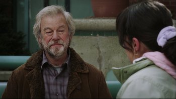 Movie still from “Away from Her” (2006), directed by Sarah Polley – An older man and a younger woman are talking to each other; Close Up shot, Over the shoulder angle