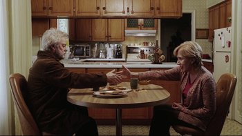 Movie still from “Away from Her” (2006), directed by Sarah Polley – A man and a woman sitting at a table with food; Medium shot, High angle