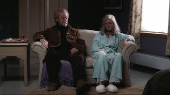Movie still from “Away from Her” (2006), directed by Sarah Polley – An older man and woman sitting on a couch; Wide shot, High angle