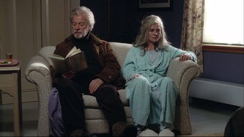 Movie still from “Away from Her” (2006), directed by Sarah Polley – An older man and woman sitting on a couch reading; Medium shot, High angle