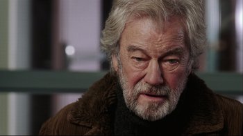 Movie still from “Away from Her” (2006), directed by Sarah Polley – An older man with a beard and a brown jacket; Close Up shot, Over the shoulder angle