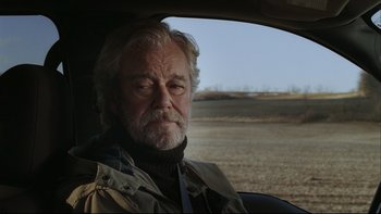 Movie still from “Away from Her” (2006), directed by Sarah Polley – An older man sitting in the drivers seat of a car; Close Up shot, Over the shoulder angle