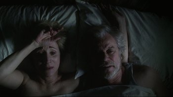 Movie still from “Away from Her” (2006), directed by Sarah Polley – A man and a woman laying in a bed together; Medium shot, Overhead angle