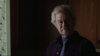 Movie still from “Away from Her” (2006), directed by Sarah Polley – An older man with white hair and a blue shirt; Close Up shot, Low angle