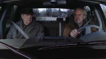 Movie still from “Away from Her” (2006), directed by Sarah Polley – Two men sitting in the back seat of a car; Medium shot, Over the shoulder angle